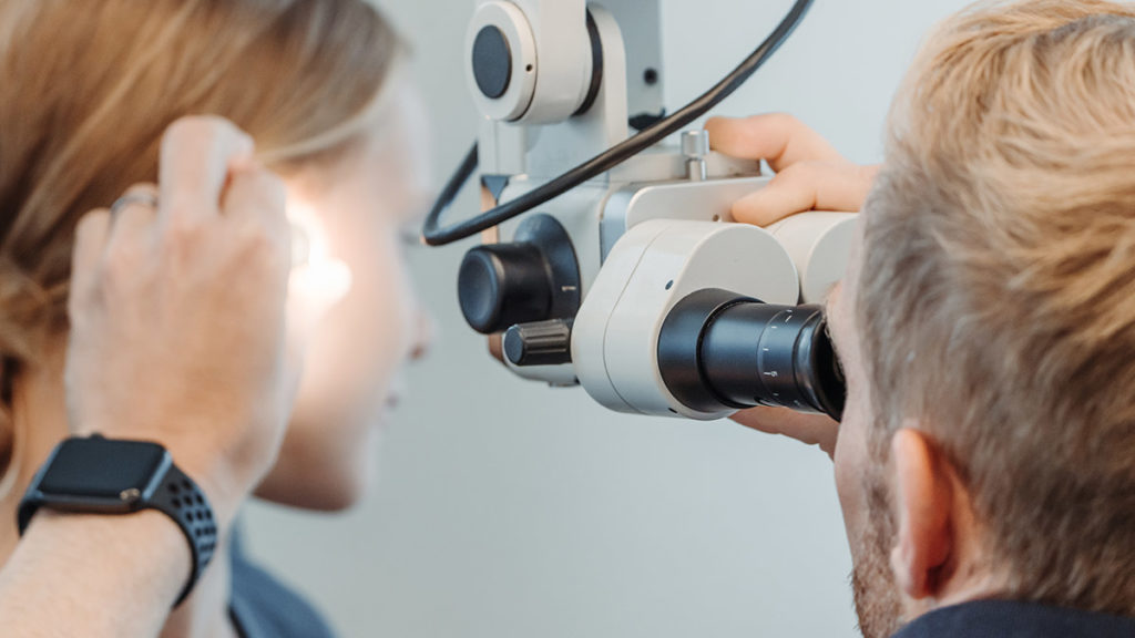 Dr. Bernhardt untersucht das Ohr einer Patientin zur Diagnose