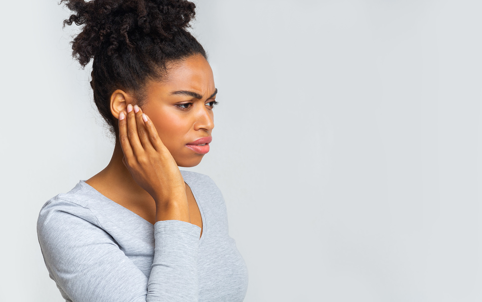 Eine Frau leidet unter Hörstörung & Tinnitus